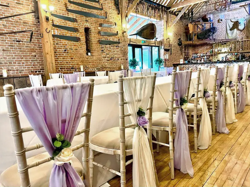 Chiavari chairs dressed with lilac and ivory chiffon drapes in a barn venue