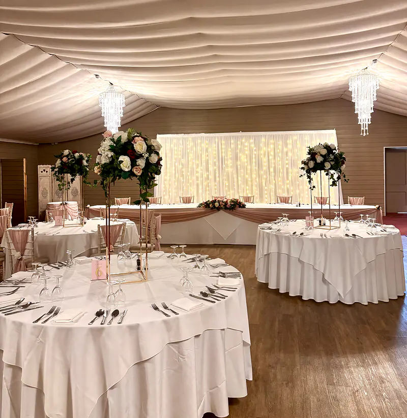 Tall floral centrepieces on gold stands in front of a starlit backdrop