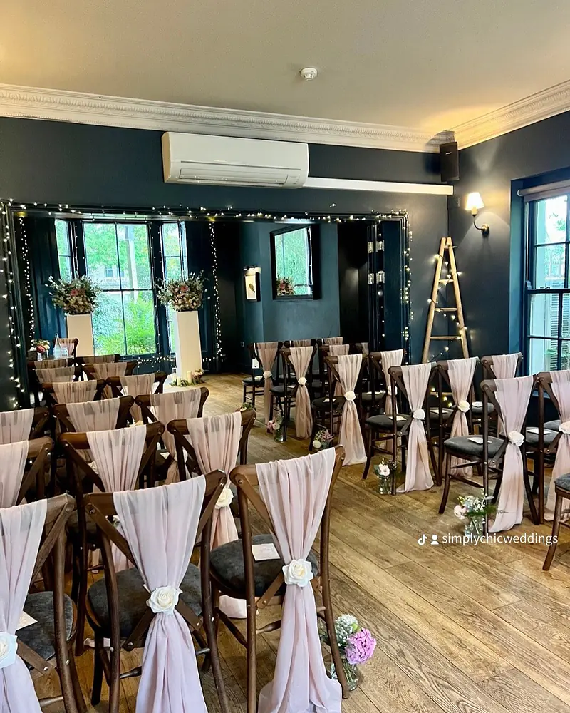 Pale pink chiffon drapes on dark wood crossback chairs