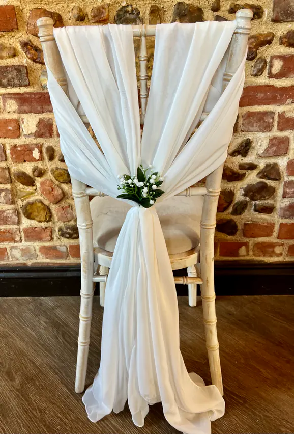 Chair dressed with double ivory chiffon drapes and gypsophila