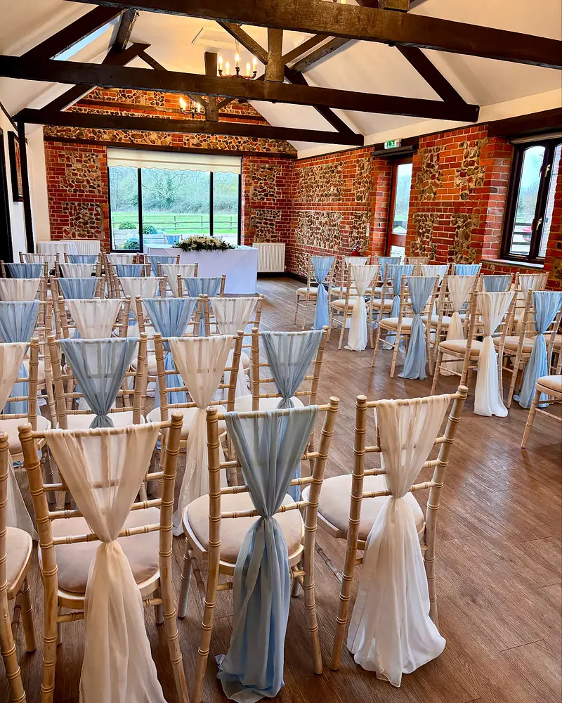Chiavari chairs with alternating ivory and pale blue chiffon drapes in the Park Room at Hunters Hall