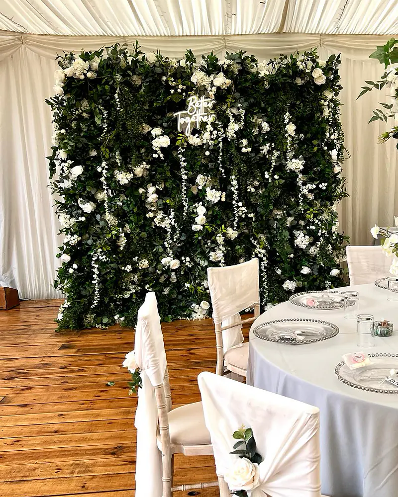 Greenery flower wall with ivory flowers and a neon Better Together sign