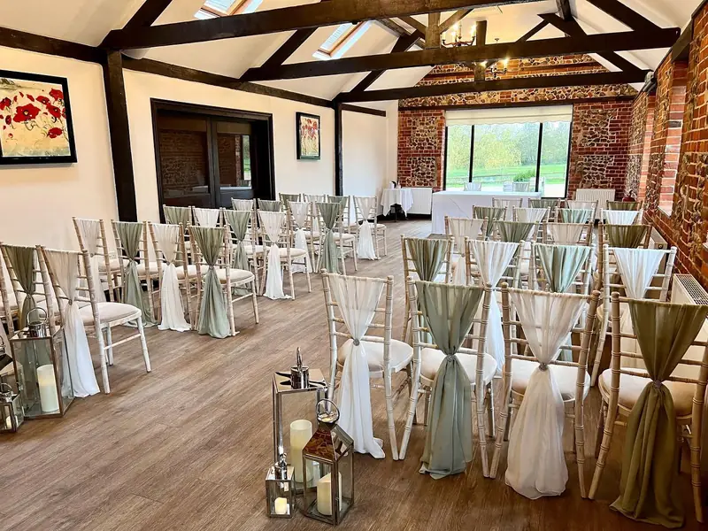 Lanterns at the end of the aisle in a ceremony room with sage and ivory chair drapes