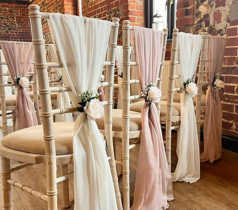 Chiavari chairs dressed with ivory and pale pink chiffon drapes