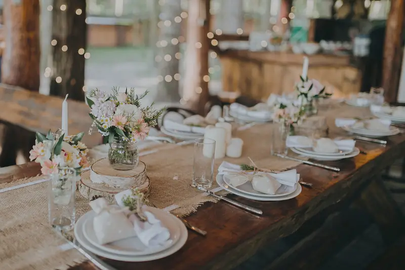 Rustic wedding table styled with hessian runners, flowers and fairy lights