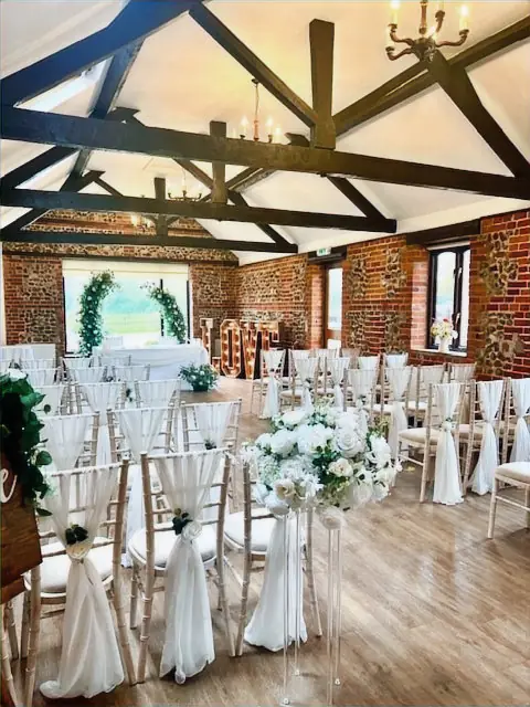 Ivory chiffon chair drapes with ivory roses and eucalyptus