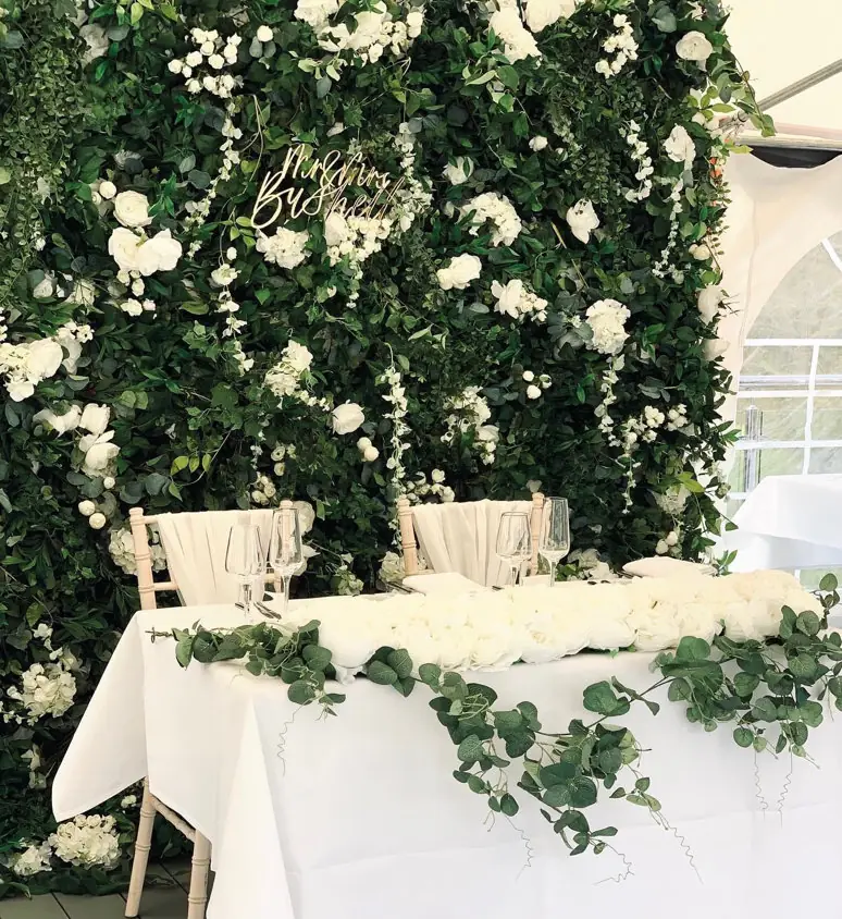 Greenery flower wall behind a sweetheart table