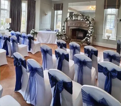 White lycra chair covers with navy organza sashes