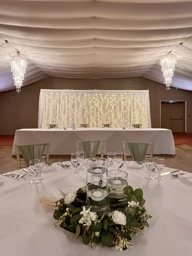 Starlit backdrop behind a top table, seen across a wreath centrepiece