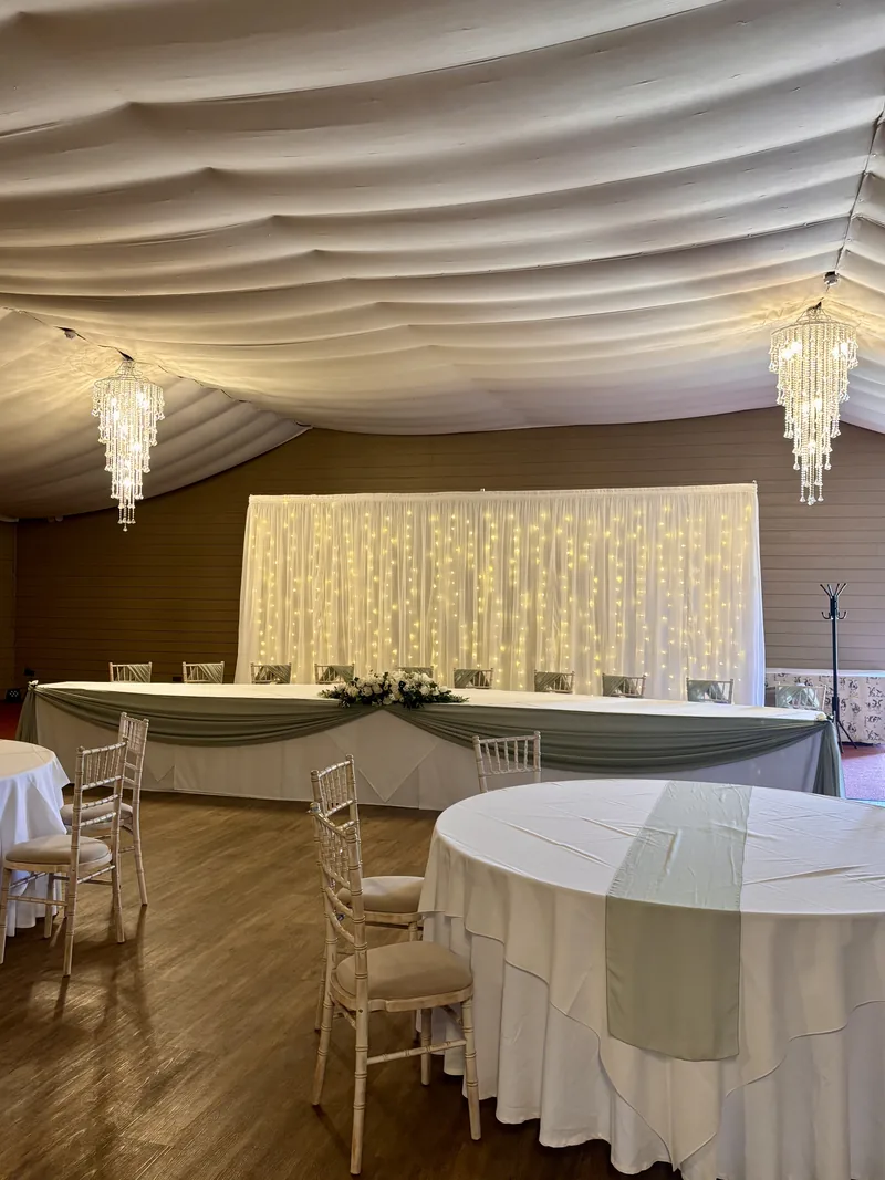 Starlit backdrop behind a top table with a sage swag, and a sage runner on a round table
