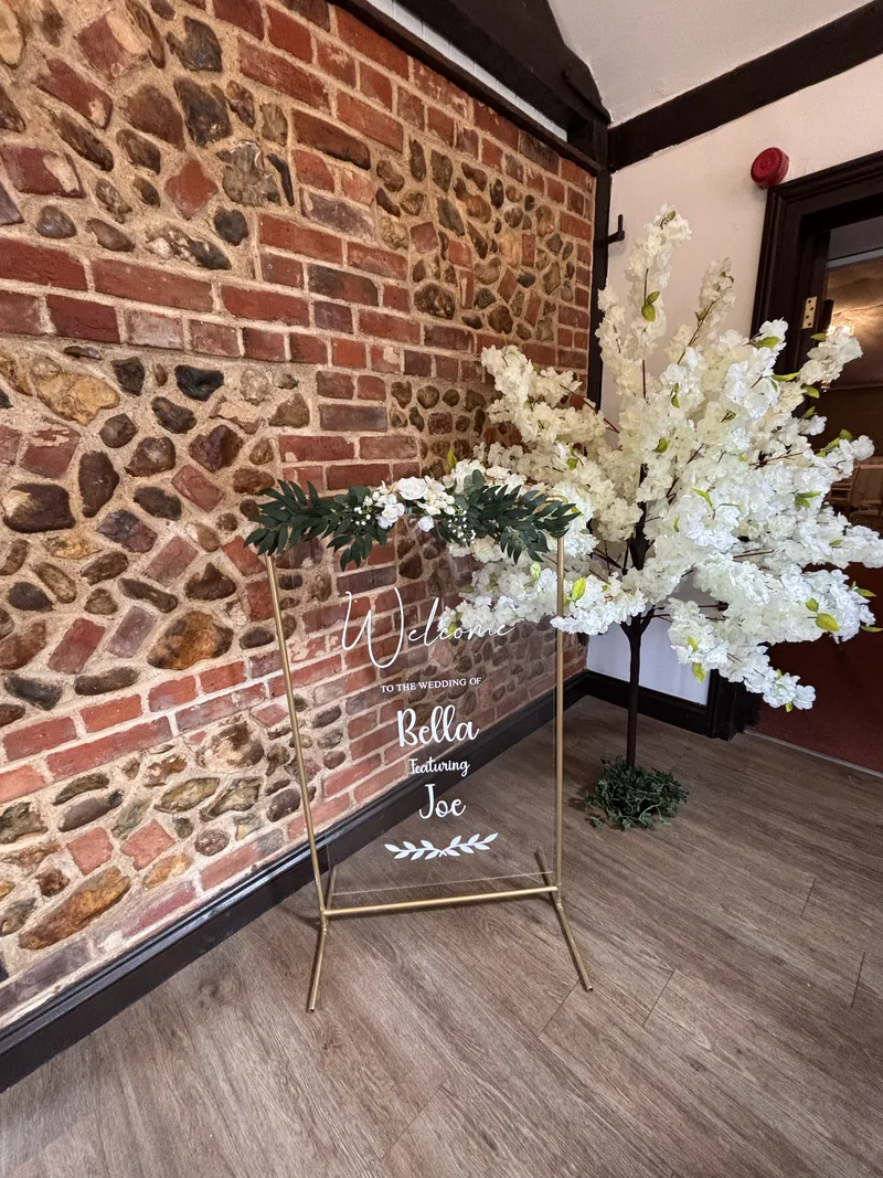 Ivory blossom tree beside an acrylic welcome sign
